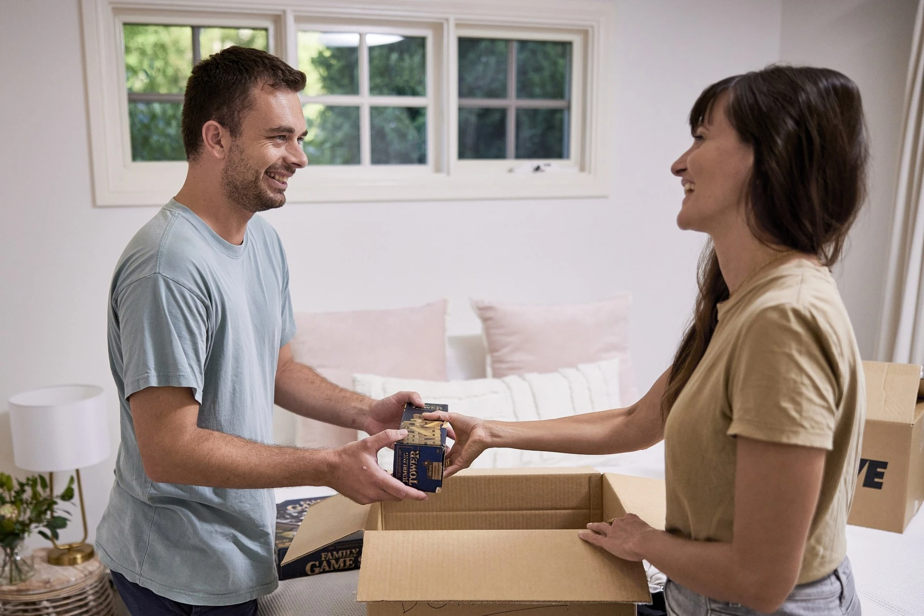 couple packing a box in the bedroom