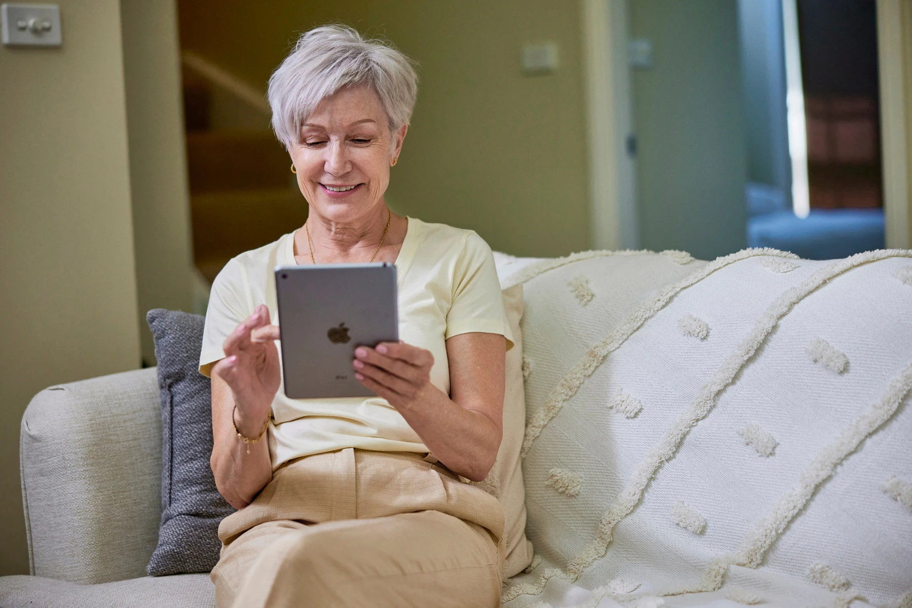 woman sitting on couch look at a tablet