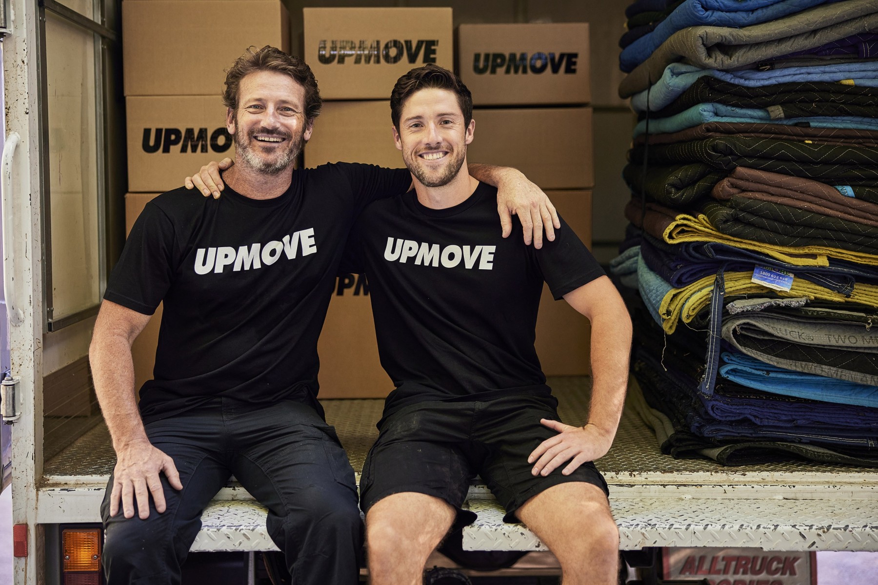 2 removalists sitting in the back of a truck