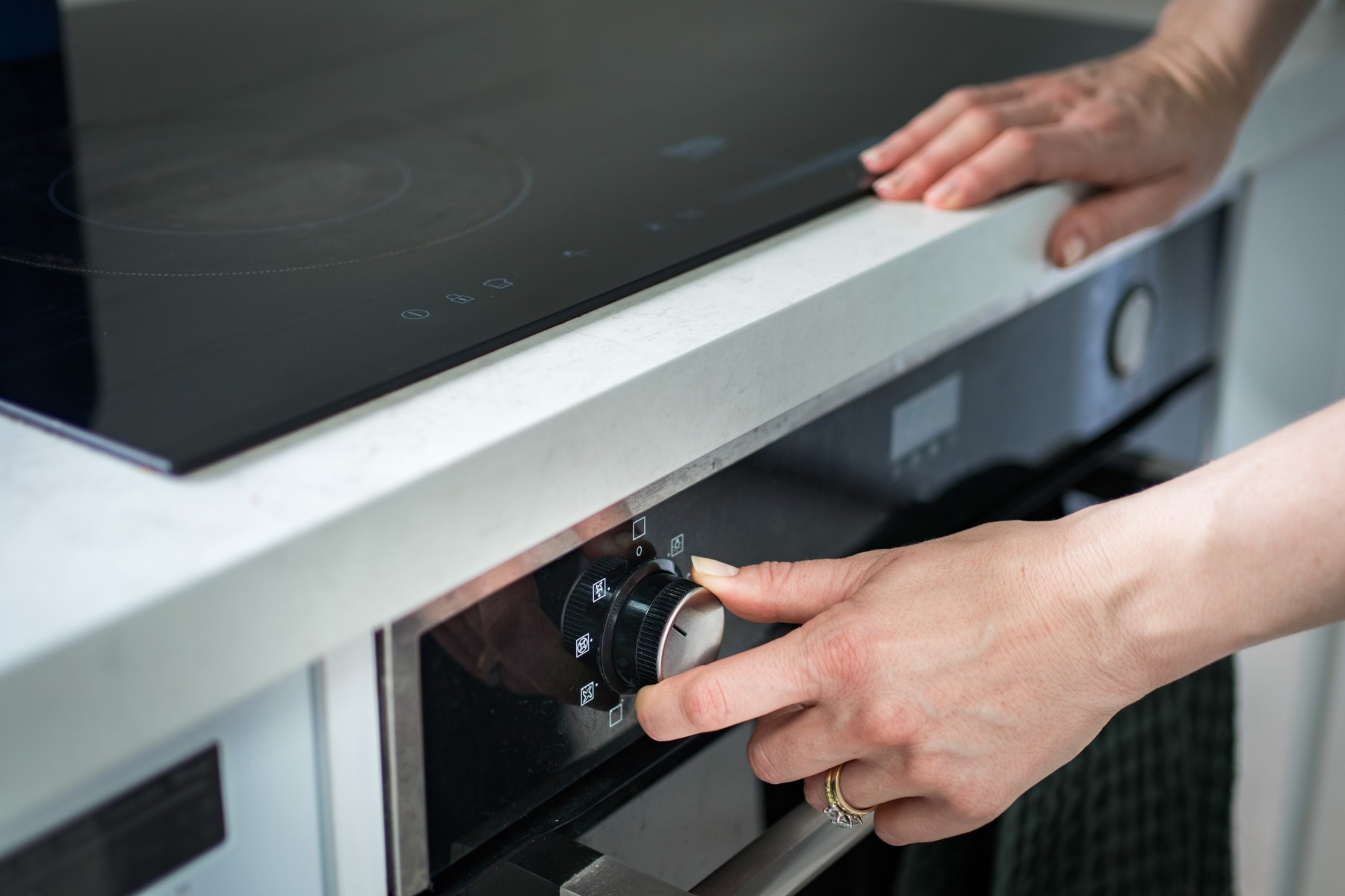 woman turning knob on oven