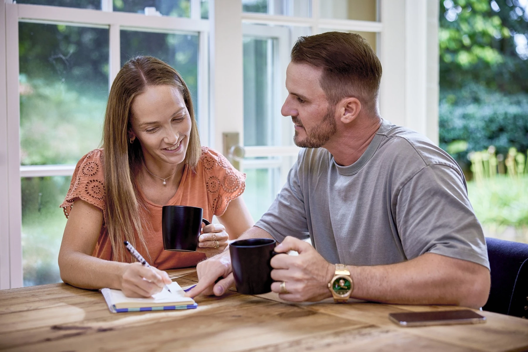 couple sitting at dining table with pen and paper