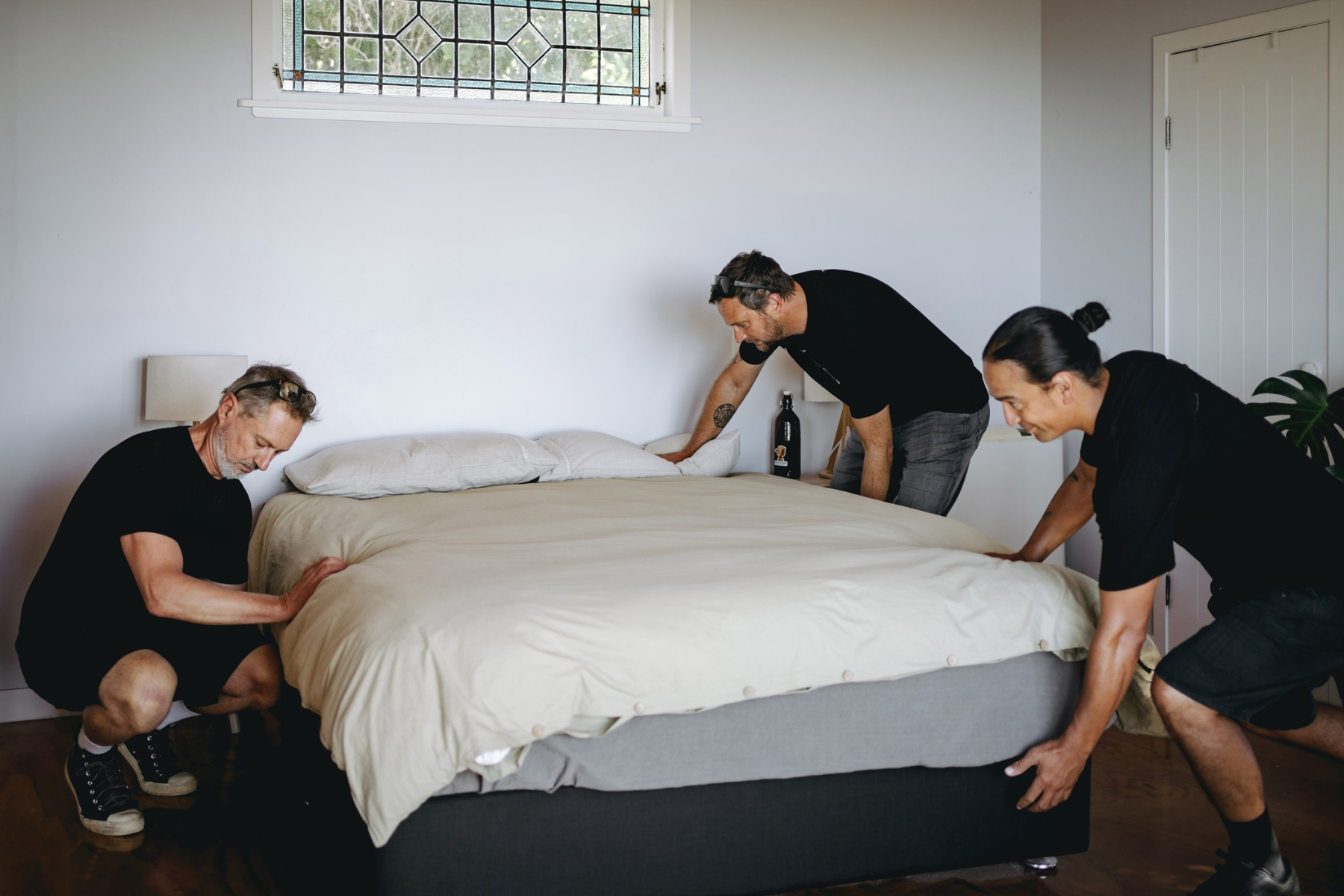 three removalists moving a bed