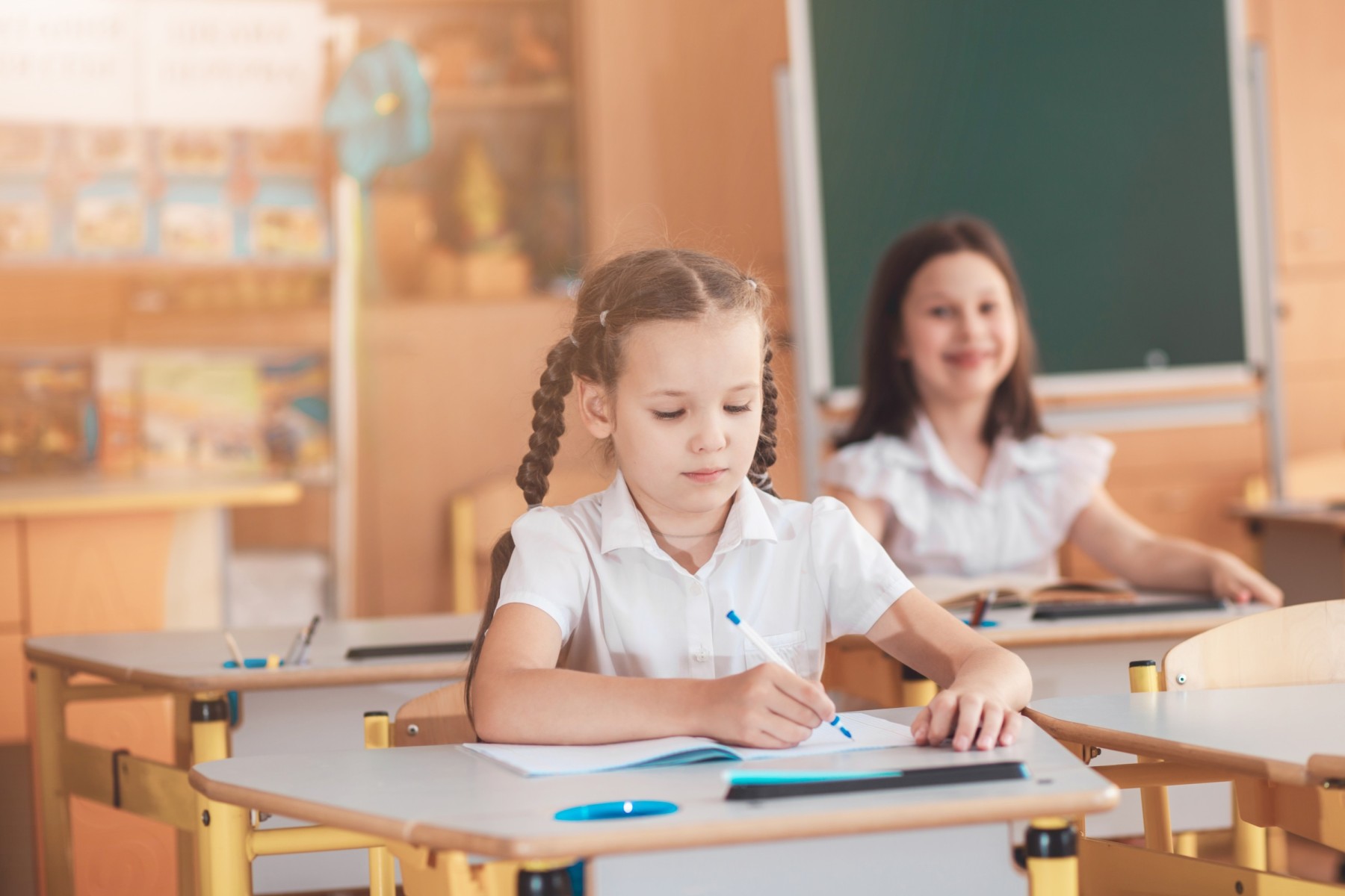 primary school girl writing in class