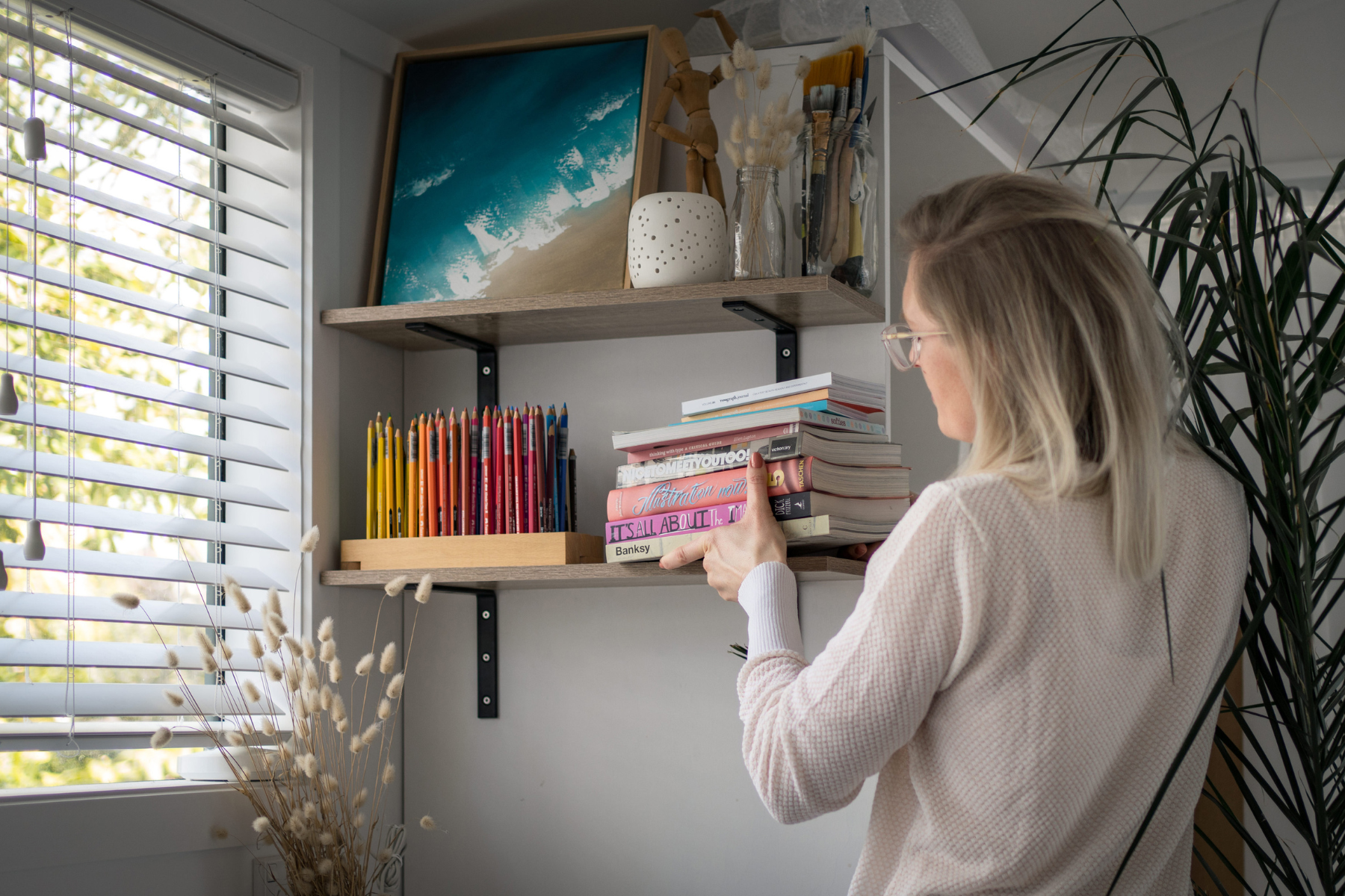 woman holding a stack of books decluttering