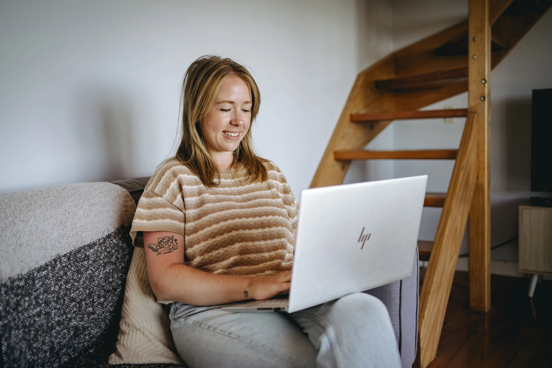 woman sitting on a couch with a laptop