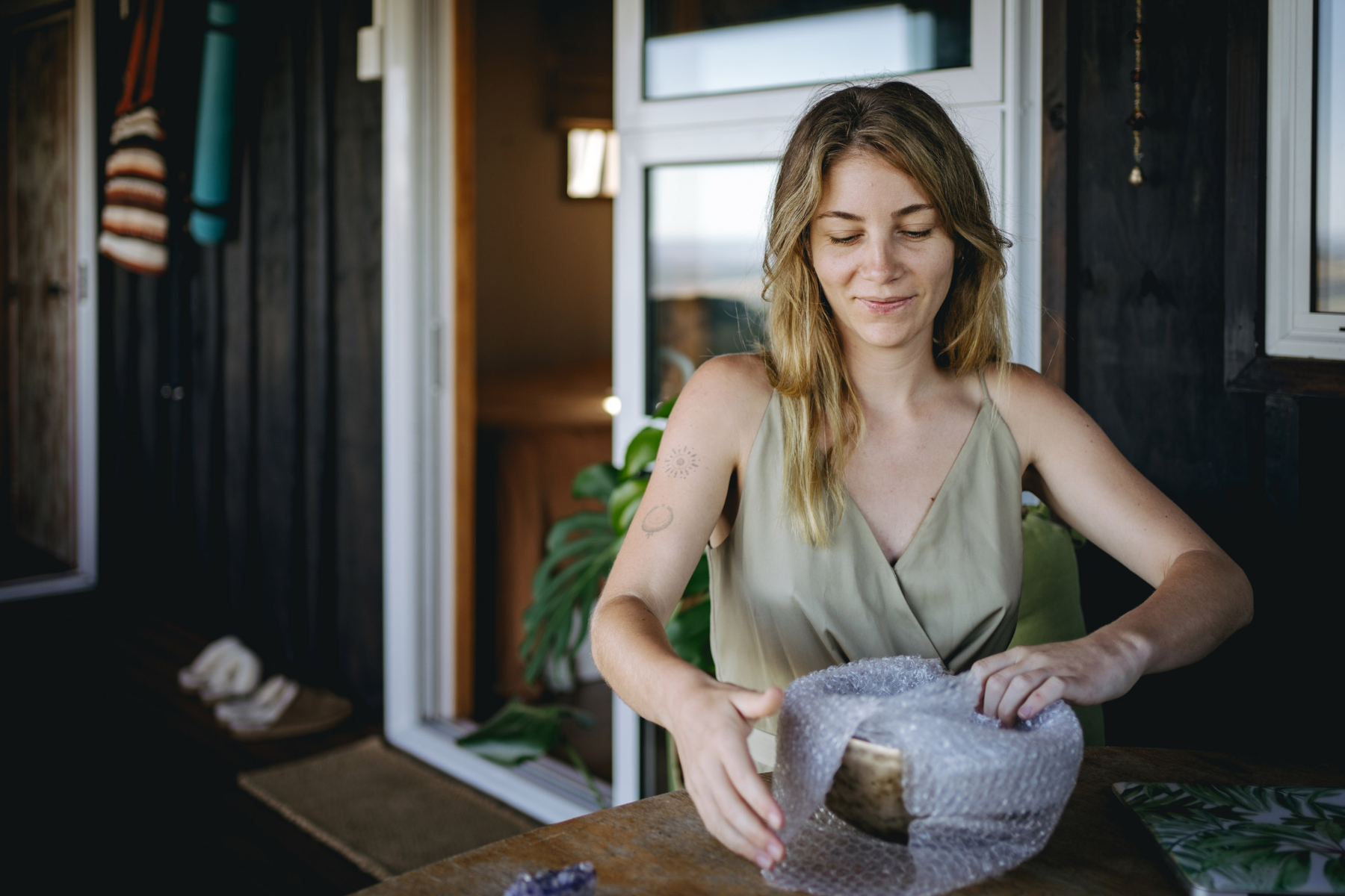 woman wrapping fragile item in bubble wrap