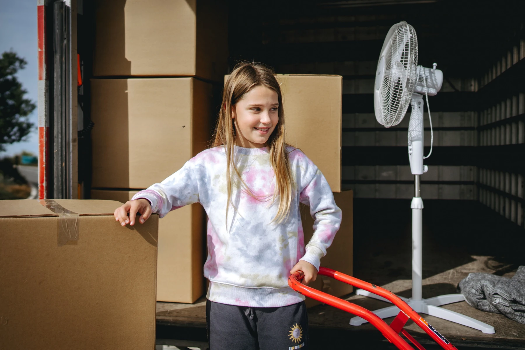 Little girl with boxes in moving truck