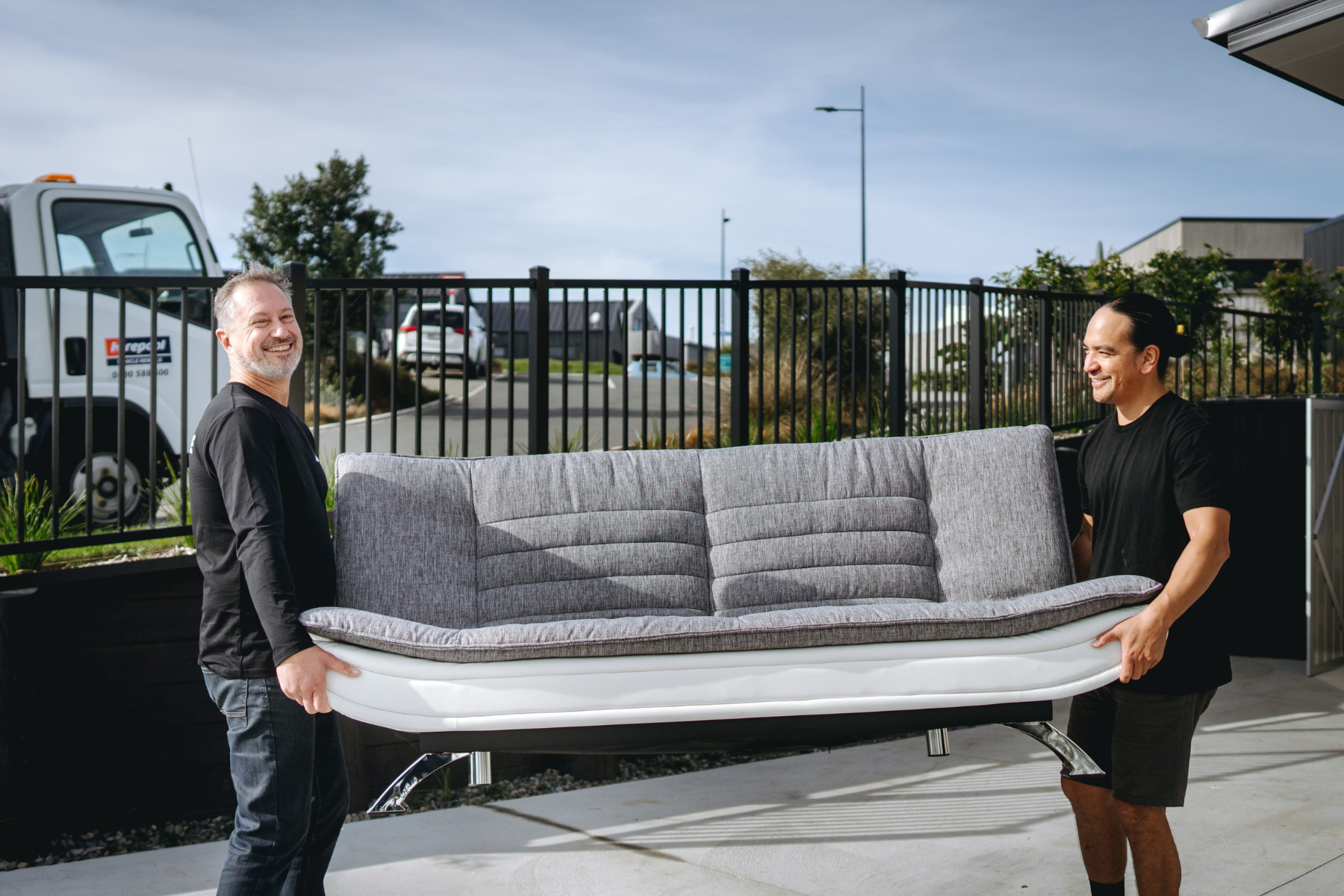 two removalists moving a second hand couch