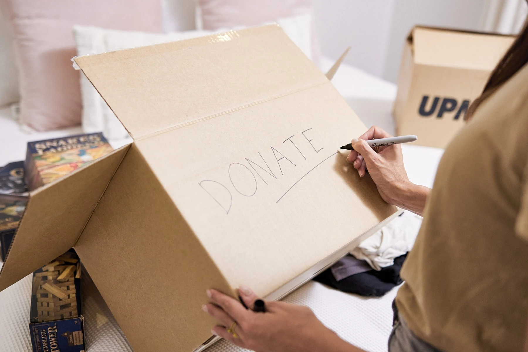 woman writing on moving box