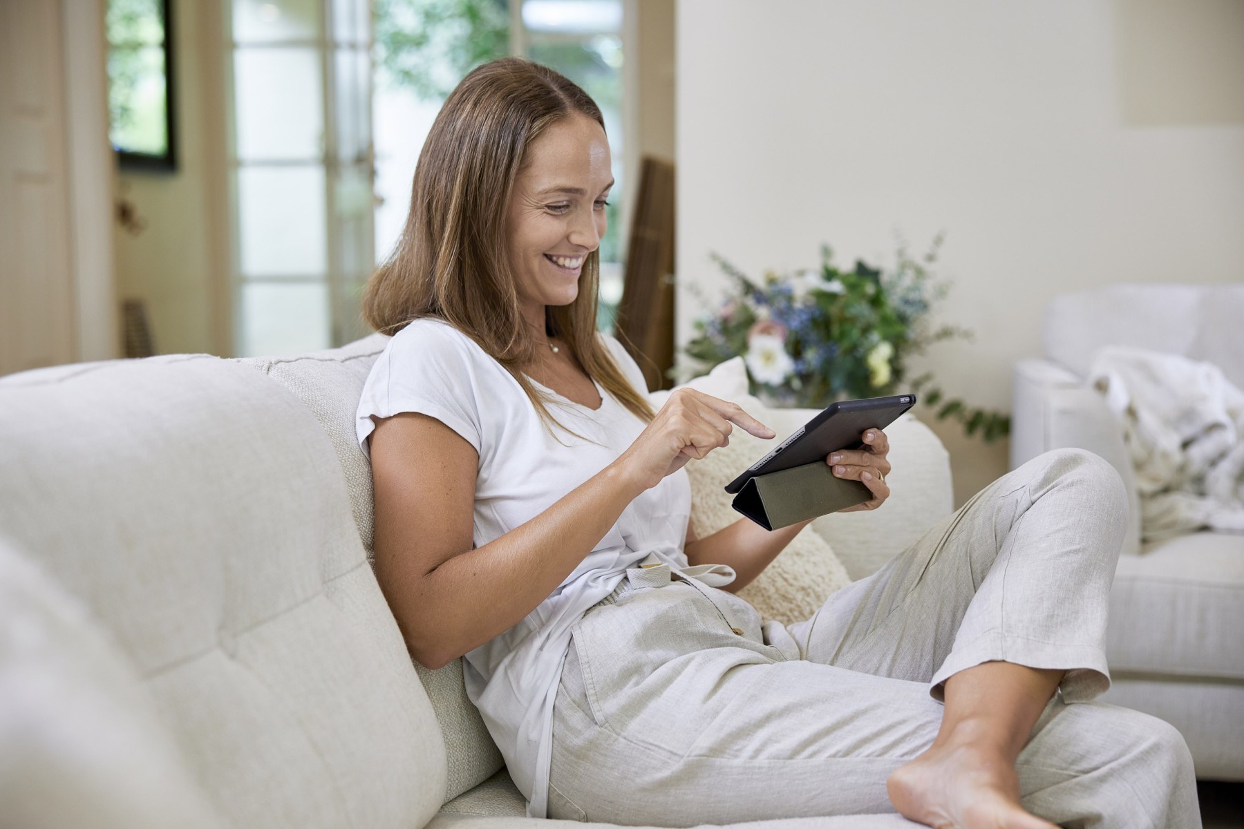 woman sitting on the couch with a tablet