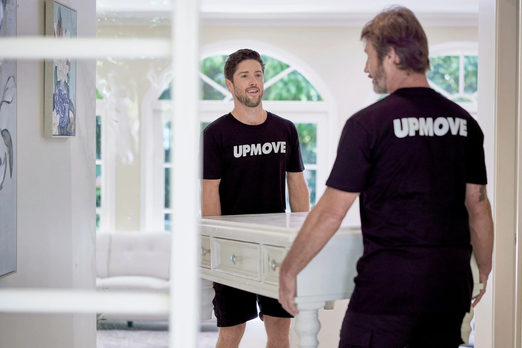 two removalists carrying coffee table