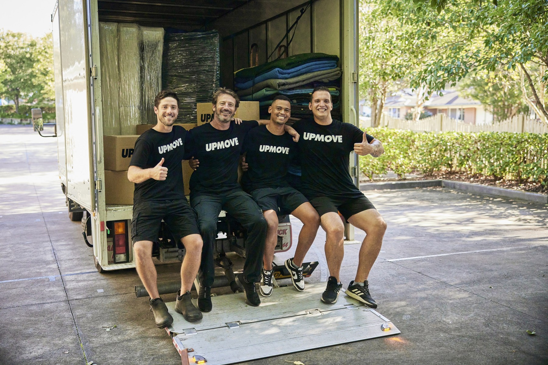 4 removalists sitting in the back of truck