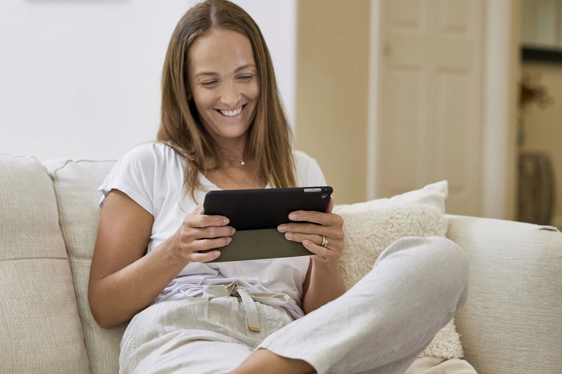 woman sitting on couch with tablet