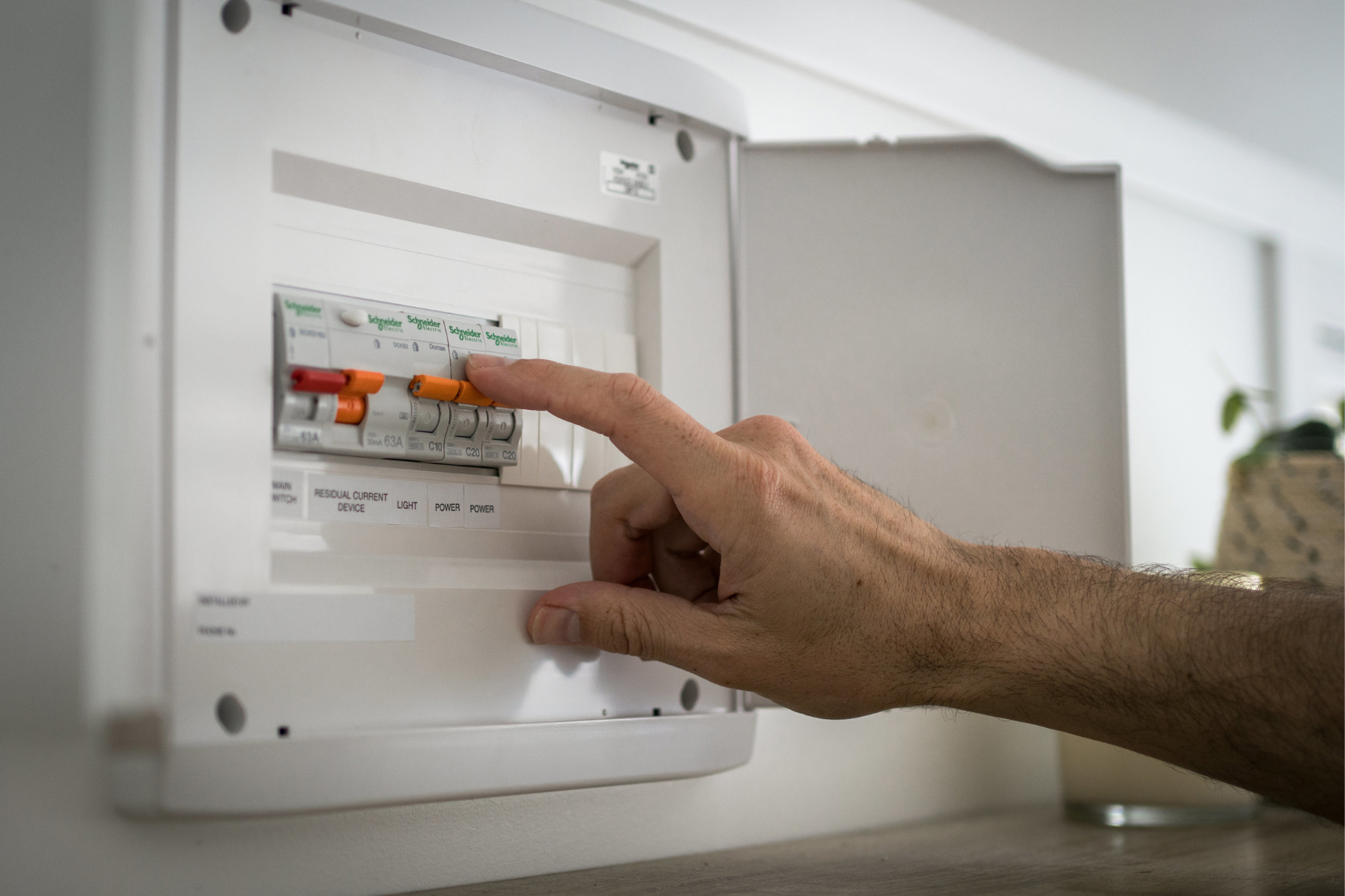 Hand switching on circuit breaker in Australian home after moving