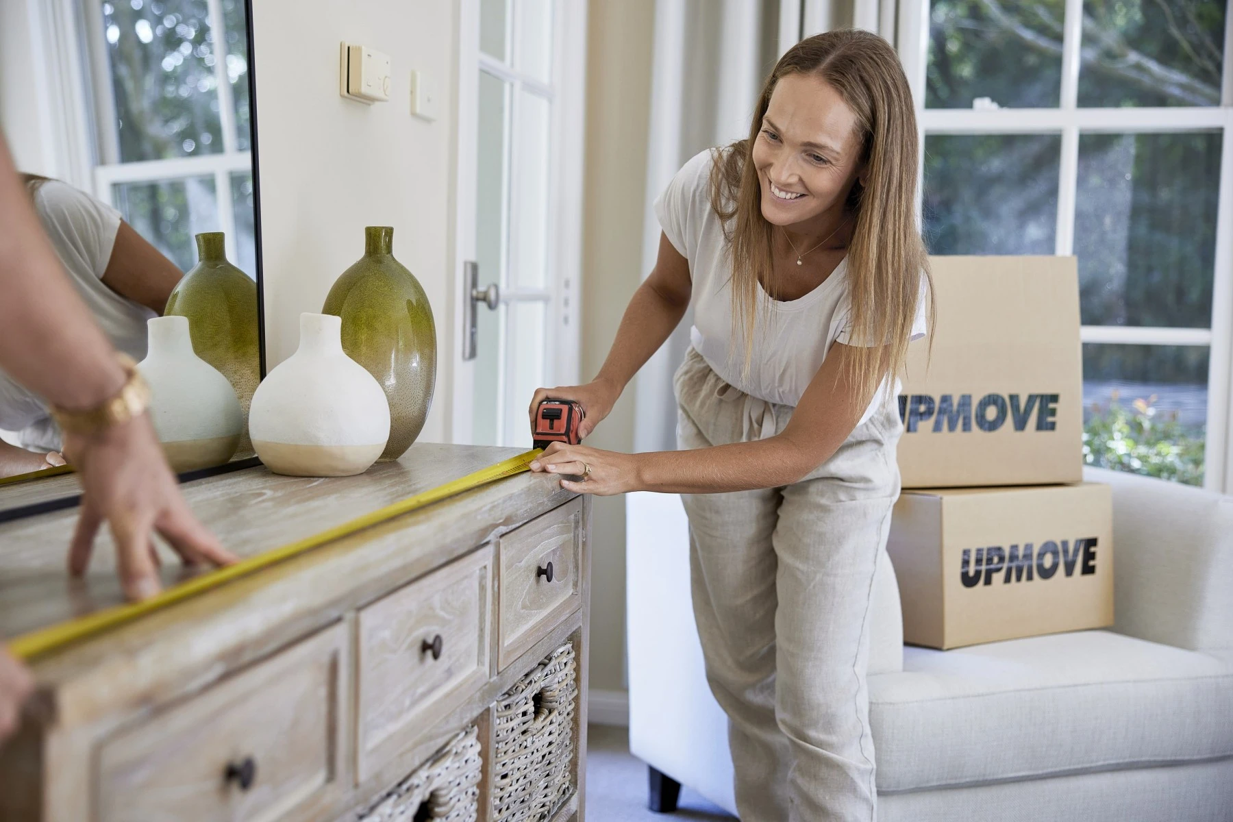 Woman measuring furniture to make sure it fits through entranceway