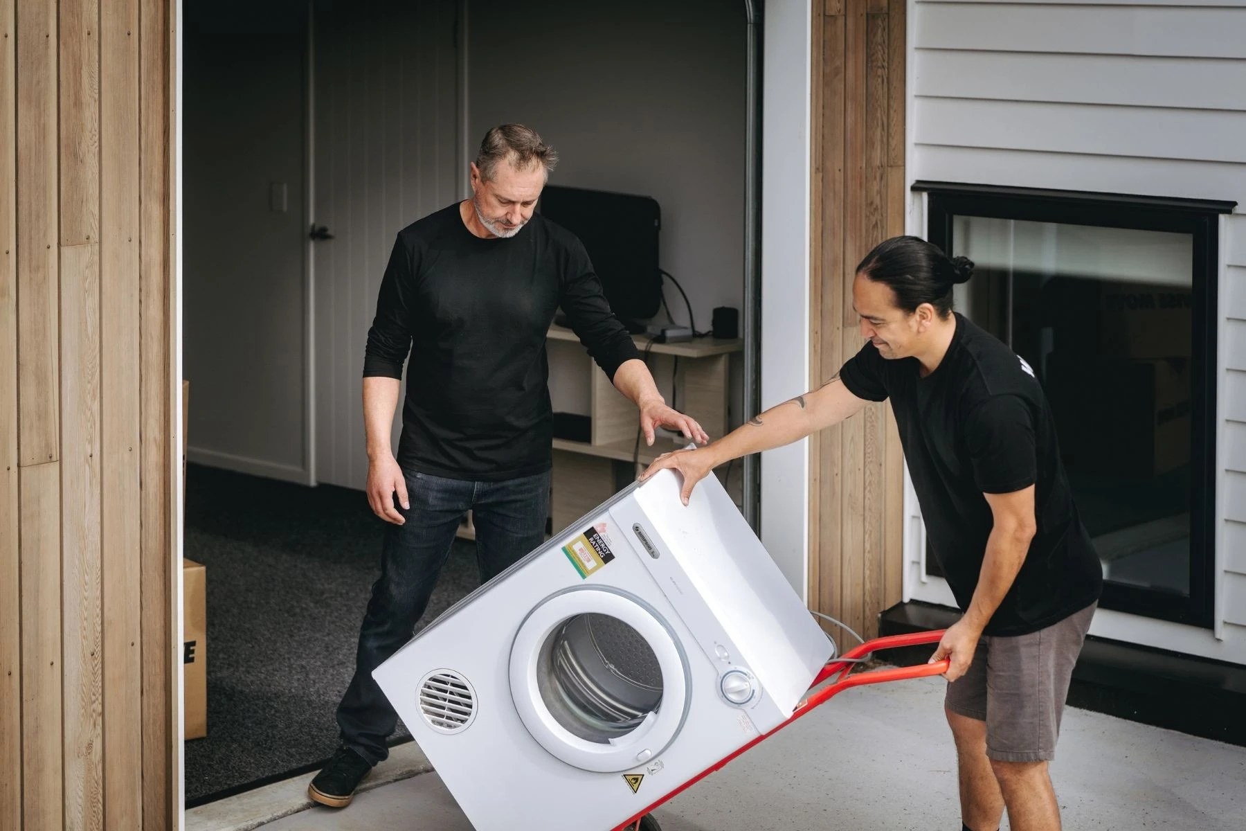removalists with washing machine on trolley
