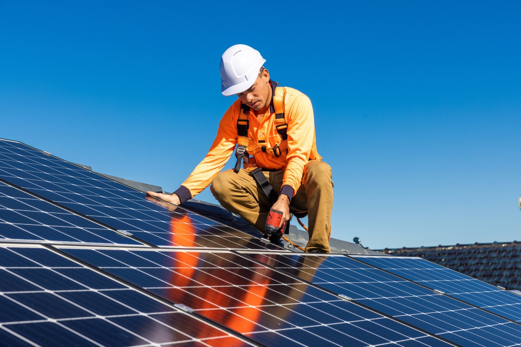 Renewable energy technician installing solar panel in Australia