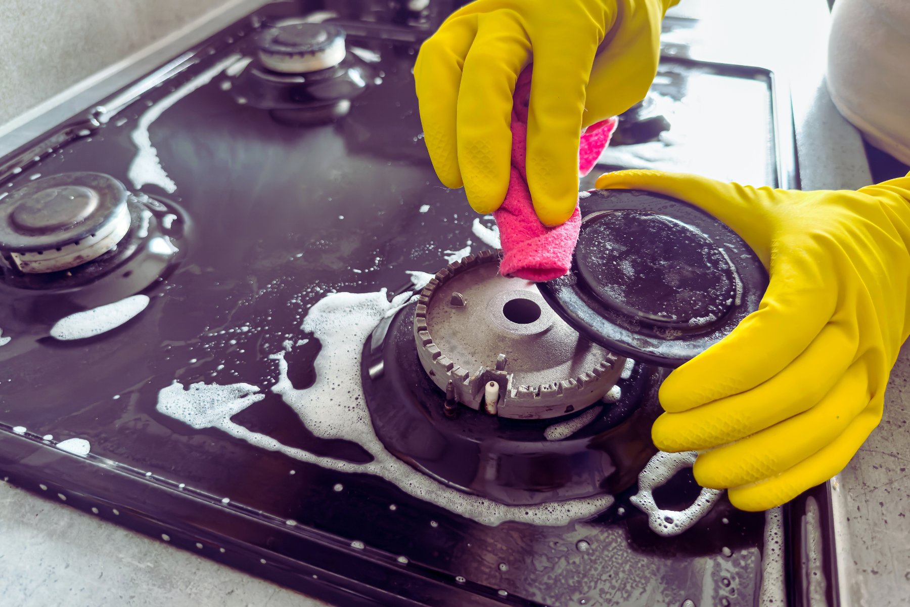 woman cleaning stove top