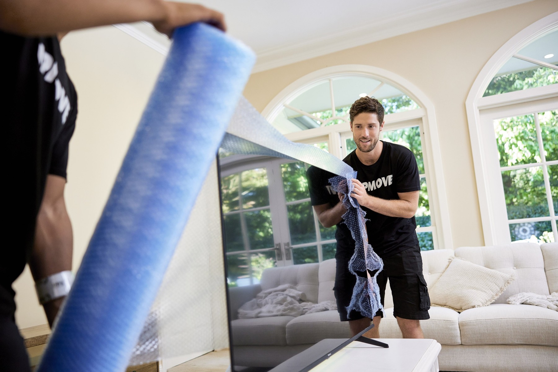 removalist wrapping tv to move