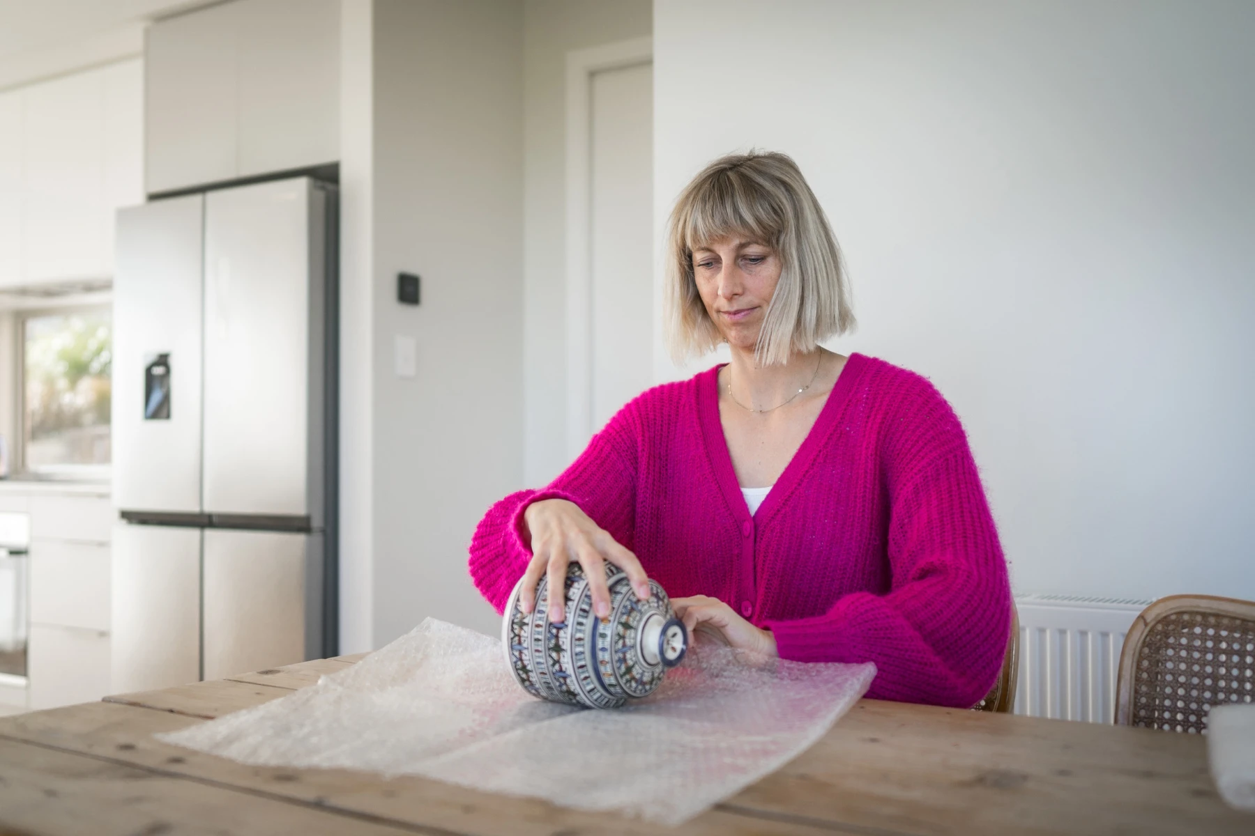 woman wrapping decor in bubblewrap