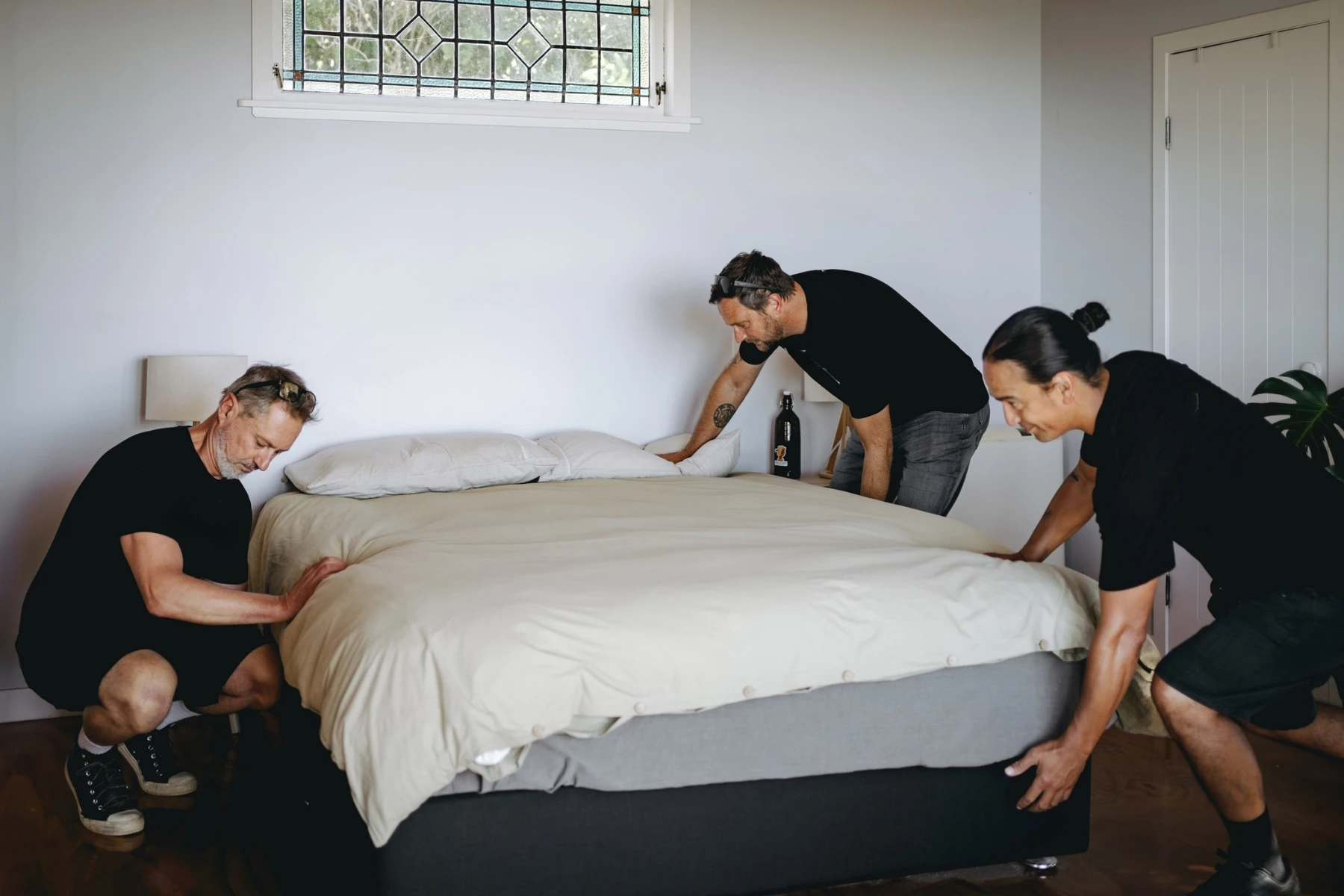 three removalists moving a bed