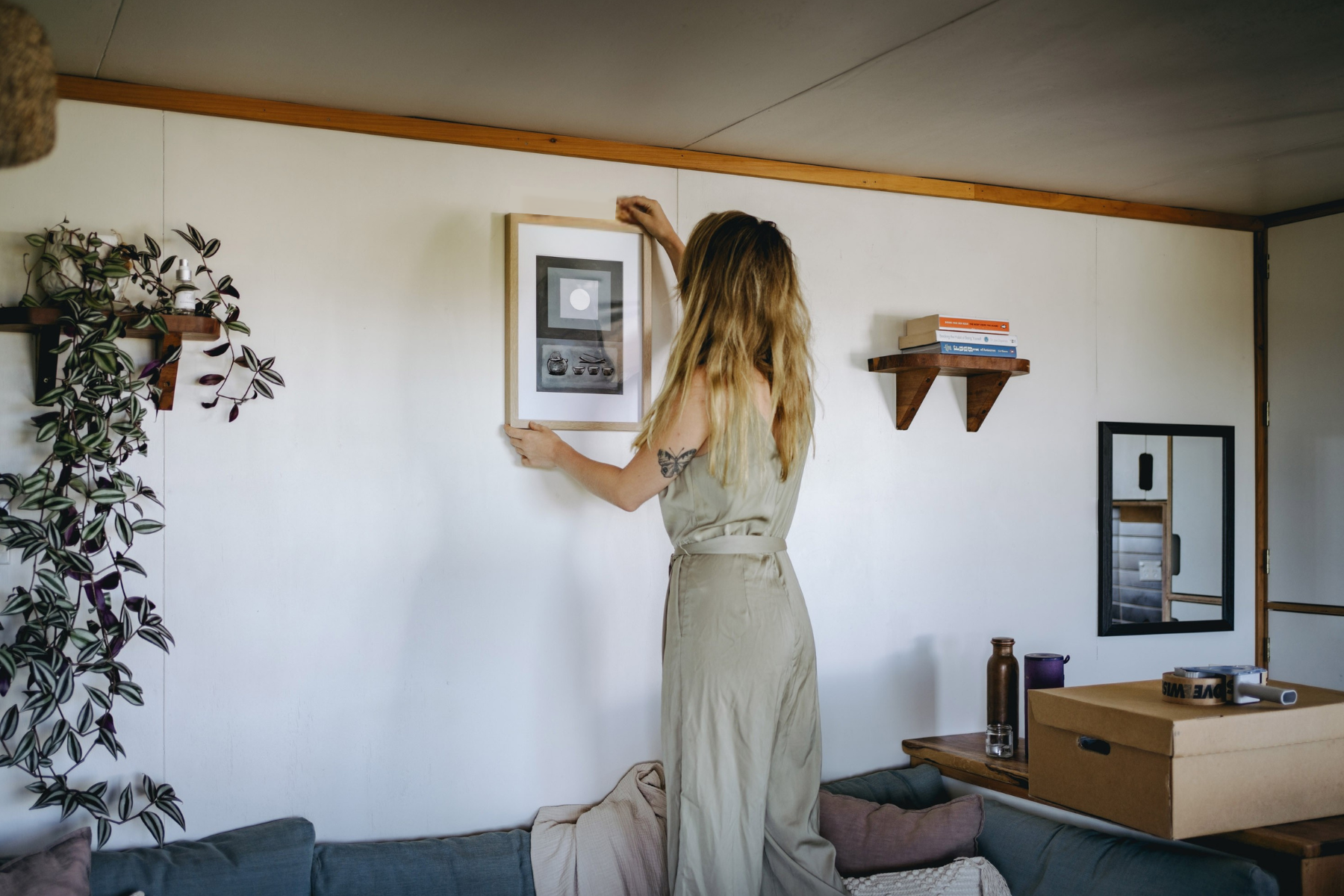 woman fixing art on wall