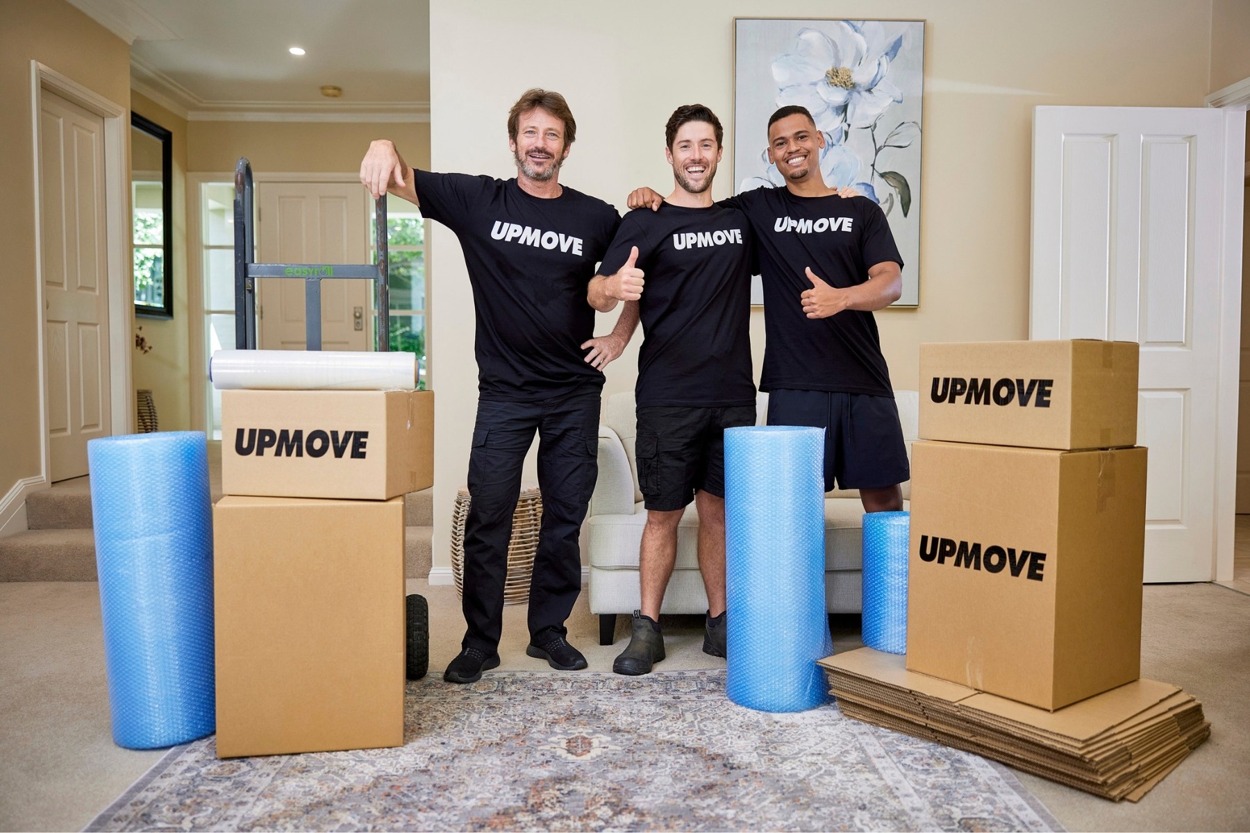 Upmove removalists standing in house with boxes and packing material