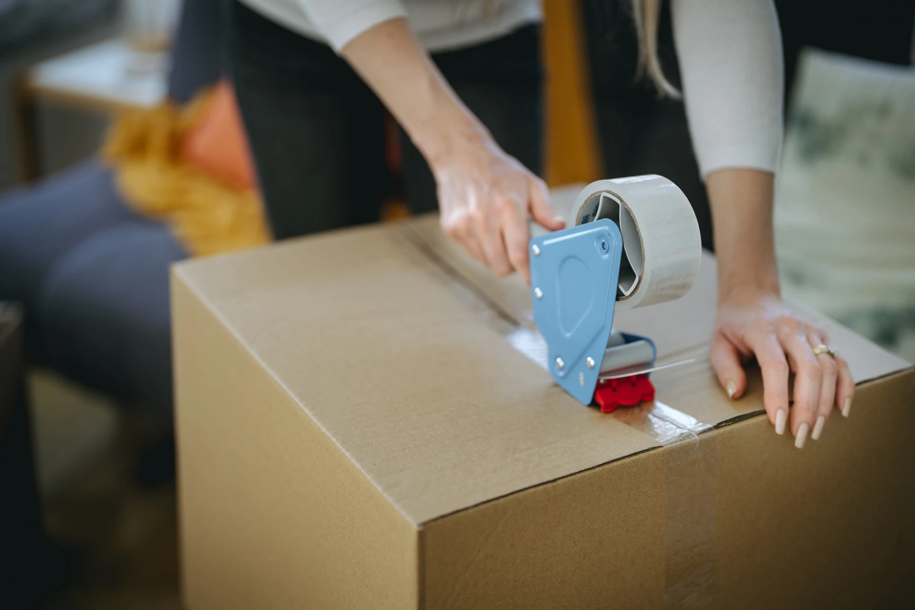 woman taping up removalist box