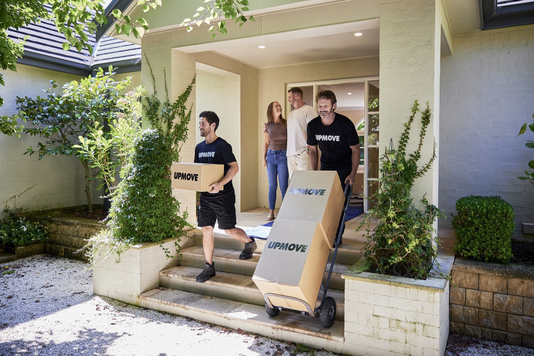 Couple watching movers carry all the boxes in a summer move