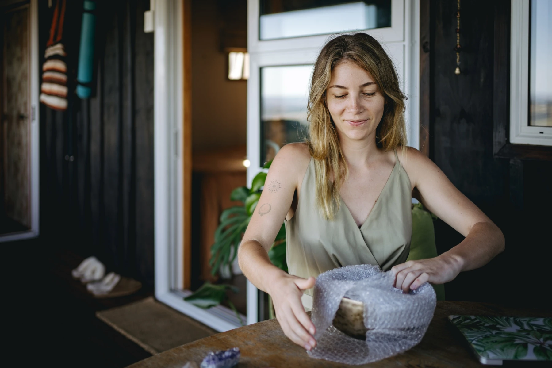 woman wrapping item in bubble wrap