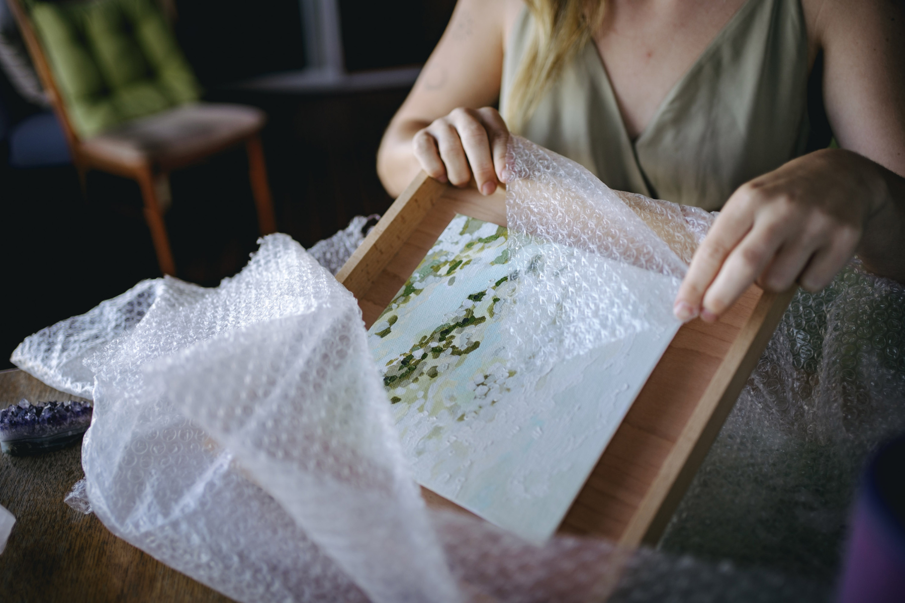woman wrapping art with bubble wrap.png