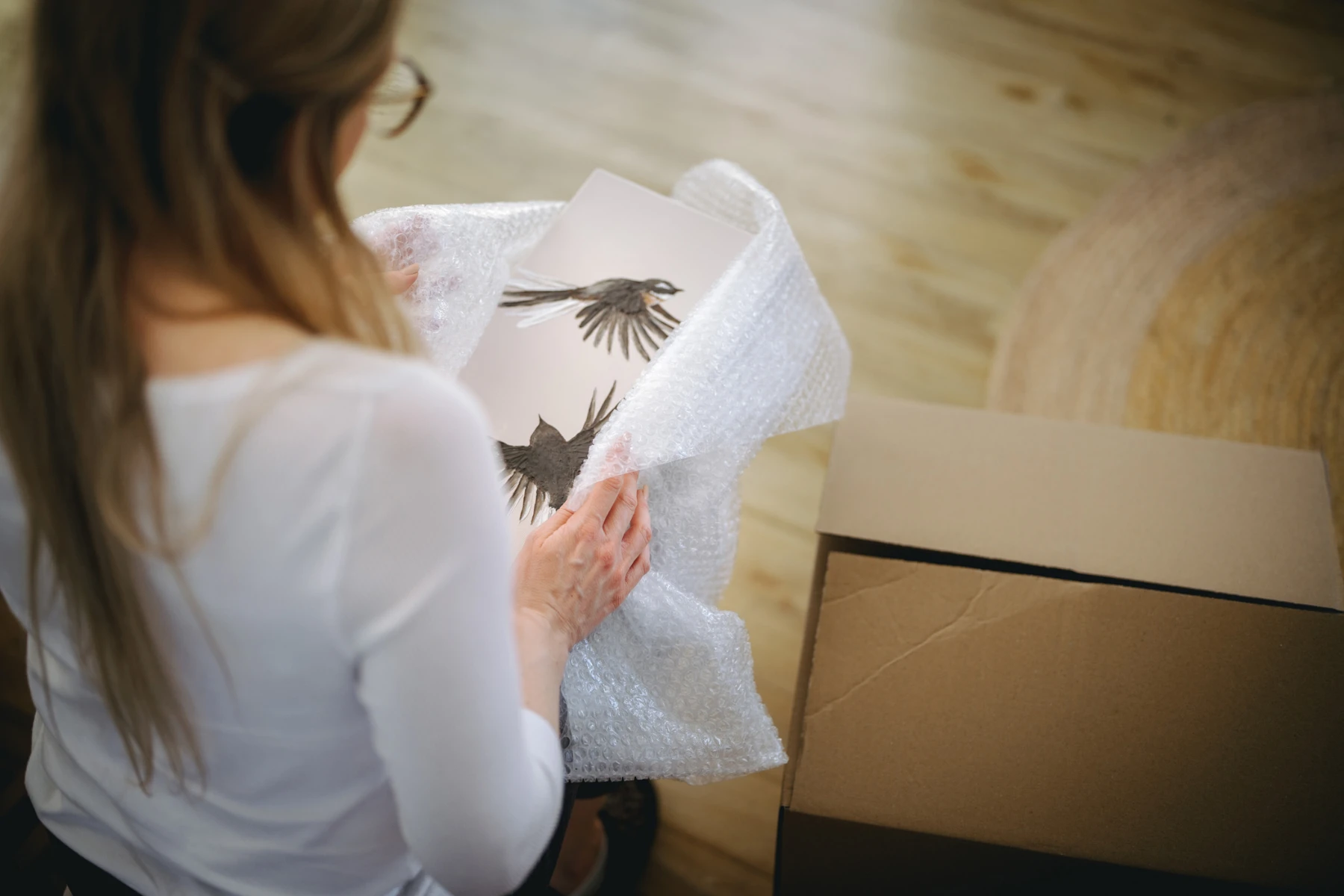 woman wrapping art in bubblewrap