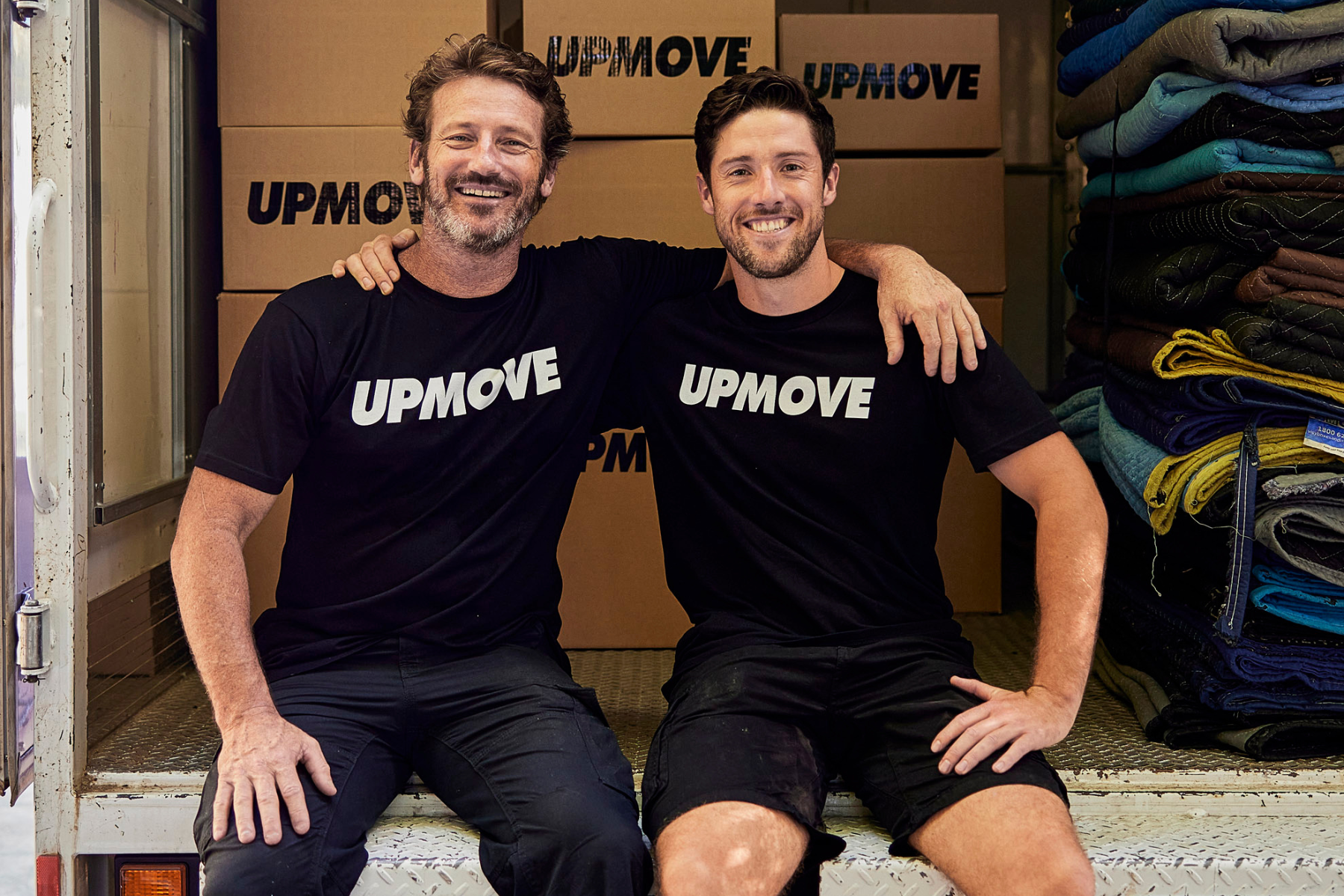 2 removalists sitting in the back of a truck