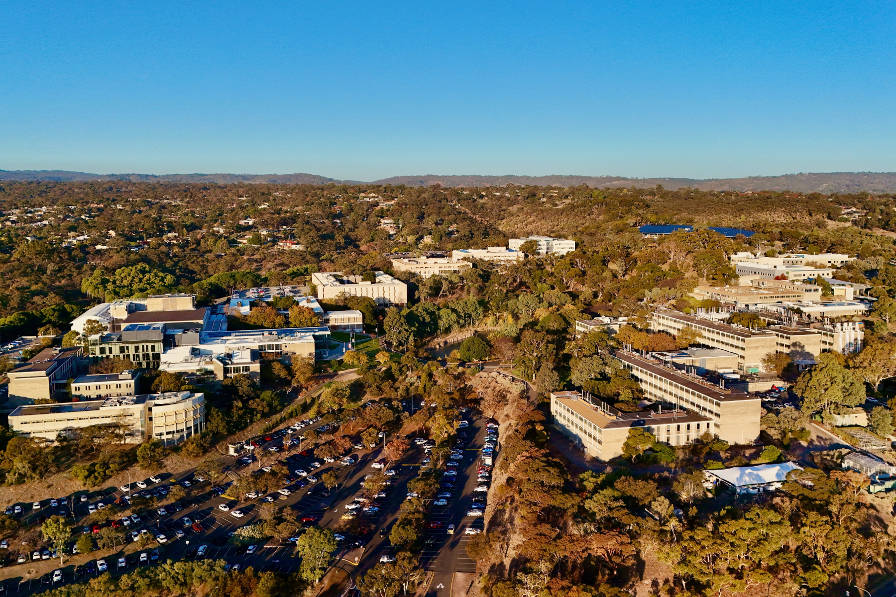 Aerial Image at Sunset Showing Academic Buildings, Carparks, Bushland, and Hilly Landscape in sunset, Flinders University, Central Park, Bedford Park, South Adelaide, South Australia