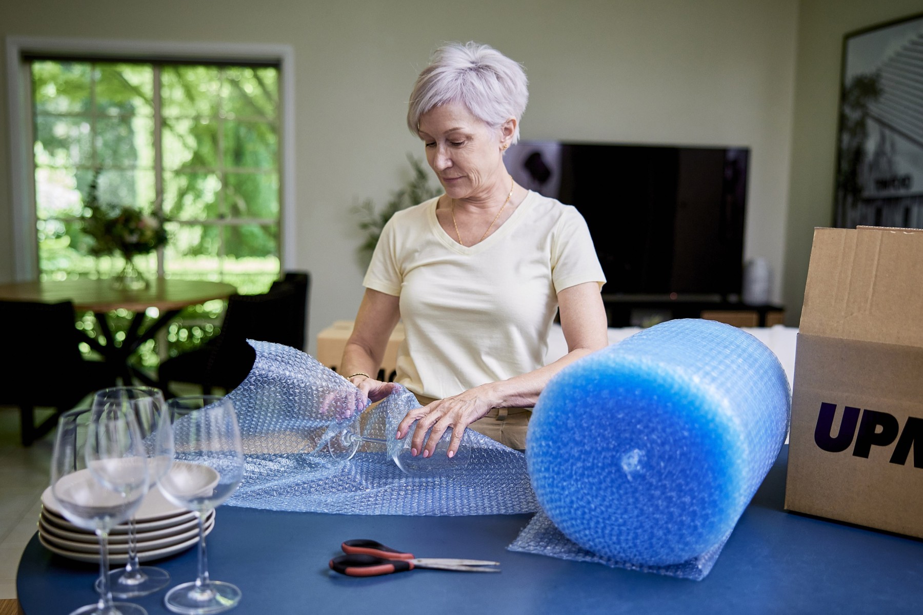 woman wrapping items in bubble wrap