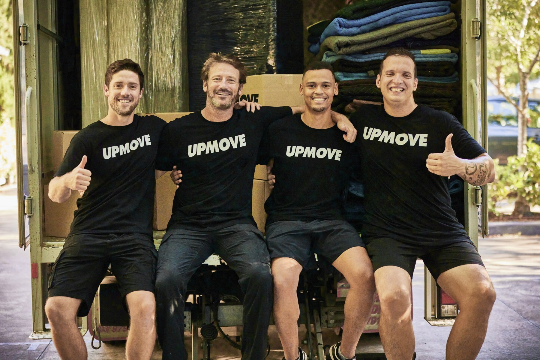 Upmove removalist team sitting on the back of a moving truck for interstate move