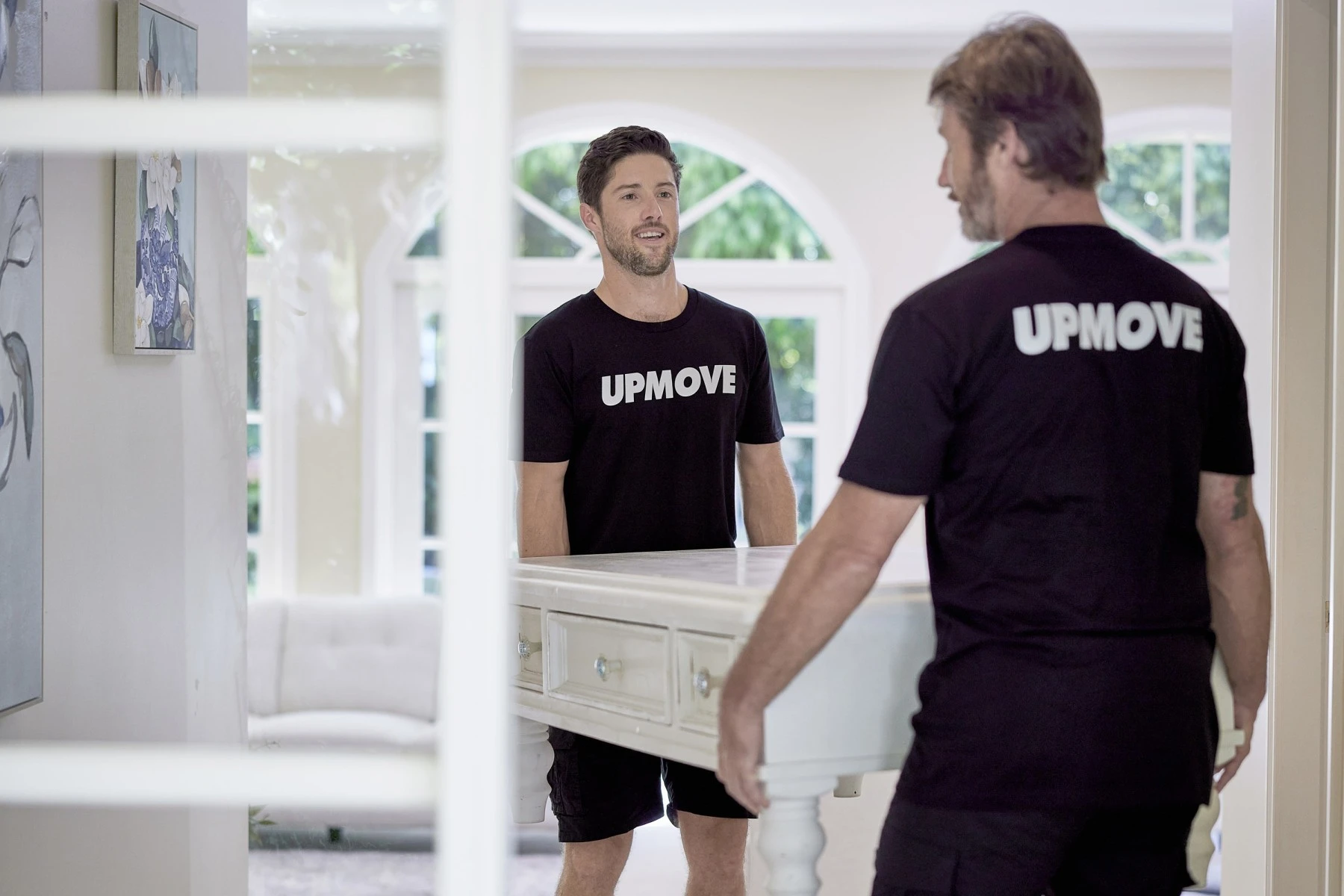 two removalists carrying a coffee table